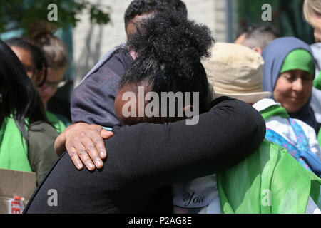 West London. London. UK vom 14. Juni 2018 - die Mitglieder der Familie legen Kränze, Blumen und Anzünden von Kerzen an der Basis von Grenfell Turm außerhalb Kensington Freizeitzentrum. Das Feuer brach am 14. Juni 2017, in dem 24-stöckigen Hochhaus Grenfell von Sozialwohnungen Wohnungen in Kensington, West London, bei denen 72 Menschen ihr Leben verloren. Credit: Dinendra Haria/Alamy leben Nachrichten Stockfoto