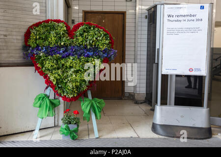 London, Großbritannien. 14 Jun, 2018. Eine Gedenkstätte Kranz am Eingang von Latimer Road Tube Station am ersten Jahrestag der Grenfell Turm Feuer. 72 Menschen starben, als der Turm im Stadtteil Kensington & Chelsea, in welcher der größte Brand seit WW2 aufgerufen wurde getötet wurden. Das 24-stöckige Hochhaus Grenfell von Sozialwohnungen Wohnungen in Kensington, West London, Vereinigtes Königreich. Es verursachte 72 Todesfälle, in der 293 Personen im Gebäude, darunter 2, die Entronnenen und verstarb im Krankenhaus. Mehr als 70 wurden verletzt und traumatisiert. Credit: RichardBaker/Alamy leben Nachrichten Stockfoto