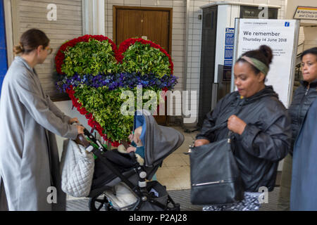 London, Großbritannien. 14 Jun, 2018. Eine Gedenkstätte Kranz am Eingang von Latimer Road Tube Station am ersten Jahrestag der Grenfell Turm Feuer. 72 Menschen starben, als der Turm im Stadtteil Kensington & Chelsea, in welcher der größte Brand seit WW2 aufgerufen wurde getötet wurden. Das 24-stöckige Hochhaus Grenfell von Sozialwohnungen Wohnungen in Kensington, West London, Vereinigtes Königreich. Es verursachte 72 Todesfälle, in der 293 Personen im Gebäude, darunter 2, die Entronnenen und verstarb im Krankenhaus. Mehr als 70 wurden verletzt und traumatisiert. Credit: RichardBaker/Alamy leben Nachrichten Stockfoto