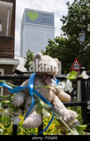 London, Großbritannien. 14 Jun, 2018. Bären Kinder und Kuscheltiere am Geländer in der Nähe, wo die Grenfell Feuer aufgetreten, am ersten Jahrestag des Hochhauses Katastrophe. 72 Menschen starben, als der Turm im Stadtteil Kensington & Chelsea, in welcher der größte Brand seit WW2 aufgerufen wurde getötet wurden. Das 24-stöckige Hochhaus Grenfell von Sozialwohnungen Wohnungen in Kensington, West London, Vereinigtes Königreich. Es verursachte 72 Todesfälle, in der 293 Personen im Gebäude, darunter 2, die Entronnenen und verstarb im Krankenhaus. Mehr als 70 wurden verletzt und traumatisiert. Credit: RichardBaker/Alamy leben Nachrichten Stockfoto