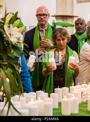 Eine Frau hält zwei Kerzen für die zwei verlorenen Familie Mitglieder während der Teilnahme an dem Service, den das Grenfell Feuerwehr Jubiläum in St. Helen's Church, South Kensington, London, England, UK, 14. Juni 2018 zu markieren Stockfoto