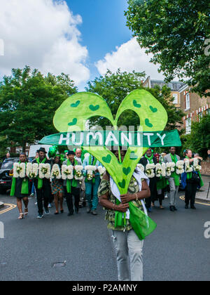 Menschen Familie und Freunde der Opfer des Grenfell Feuer in den Spaziergang in Richtung der Turm, auf dem ein Jahr Jubiläum. Führende im März eine "Menschheit" Banner ist clarrie Mendy-Solomon, 2 Familienmitglieder im Feuer, London, England, UK, 14. Juni 2018 Stockfoto