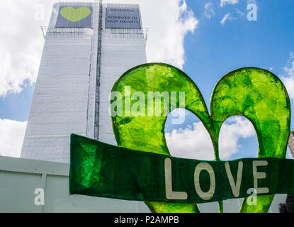 Ein riesiges Banner mit dem Wort "Liebe" an der Basis der Grenfell Turm links ist der Jahrestag des Brandes, London, England, Großbritannien, 14. Juni 2018 Stockfoto