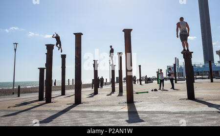 Brighton UK 14. Juni 2018 - Parkour Darsteller Sprung über die Säulen der Goldene Spirale Installation neben dem West Pier von Brighton direkt am Meer an einem herrlichen sonnigen Abend Foto von Simon Dack: Simon Dack/Alamy leben Nachrichten Stockfoto