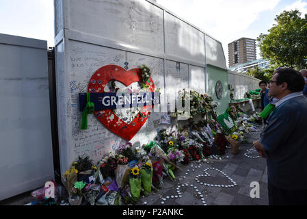 London, Großbritannien. 14. Juni 2018. Die Mauer der Erinnerung an der Basis der Grenfell Tower. Tribute gibt es in der Umgebung die 72 Leute, die auf dem Jahrestag der Tragödie Grenfell Turm, wo eine kleine Küche Feuer in die größte Blaze in Großbritannien gesehen seit dem Zweiten Welt Krieg getötet wurden, zu erinnern. Viele Menschen tragen grüne Schals - Grün für Grenfell - in Erinnerung an diese verloren. Credit: Stephen Chung/Alamy leben Nachrichten Stockfoto