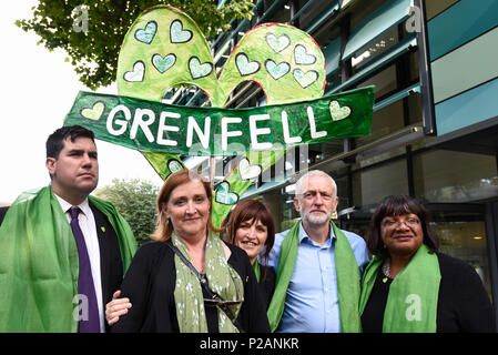 London, Großbritannien. 14. Juni 2018. Jeremy Corbyn, der Führer, (2. rechts), Emma Dent Coad, Labour MP für Kensington (2. links) und anderen Labour-abgeordneten posieren für ein Foto in der Nähe des Grenfell Tower. Tribute gibt es in der Umgebung die 72 Leute, die auf dem Jahrestag der Tragödie Grenfell Turm, wo eine kleine Küche Feuer in die größte Blaze in Großbritannien gesehen seit dem Zweiten Welt Krieg getötet wurden, zu erinnern. Viele Menschen tragen grüne Schals - Grün für Grenfell - in Erinnerung an diese verloren. Credit: Stephen Chung/Alamy leben Nachrichten Stockfoto