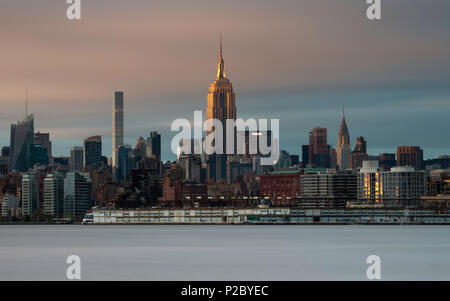 Panoramablick auf die lange Belichtung auf das Empire State Building und die Skyline von Manhattan bei Sonnenuntergang von über den Hudson River in New Jersey, New York, USA Stockfoto