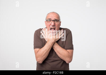 Reifer Mann unter schrecklichen Schmerzen in Hals, wegen der Krankheit. Stockfoto