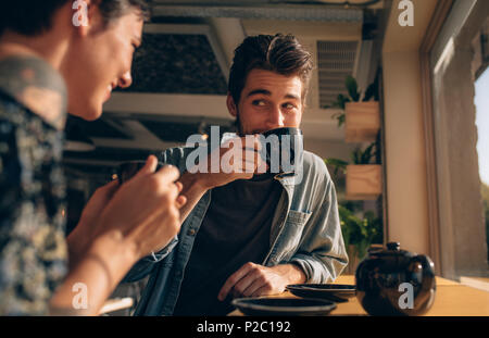 Junger Mann trinkt Kaffee mit seiner Freundin im Coffee Shop. Paar Kaffee zusammen in ein Restaurant. Stockfoto