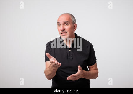 Portrait von Reifen kaukasischen ein junger Mann überrascht und Fragen mit der Hand angehoben. Stockfoto