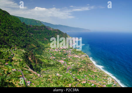 Atemberaubende Aussicht von oben an der Nordküste der Insel Madeira und tiefen blauen Atlantik. Santana Stadt und seine Vorstädte sind umgeben von hohen Bergen Stockfoto