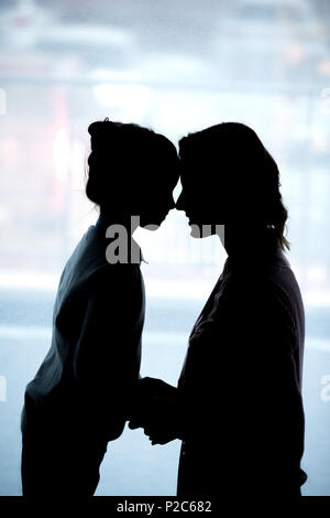 Silhouetten von Mutter und Tochter berühren mit der Stirn zu Hause Stockfoto