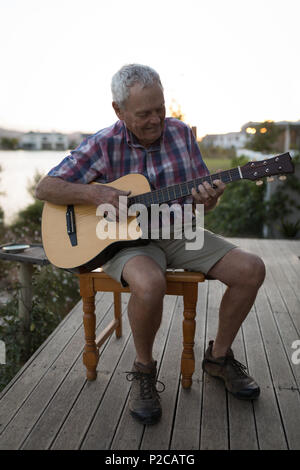 Senor Mann spielt Gitarre in der Veranda Stockfoto