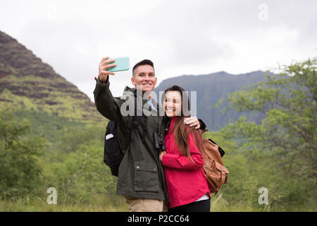 Paar unter selfie mit Handy in der Landschaft Stockfoto