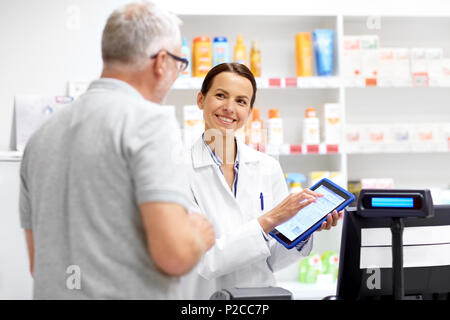 Apotheke und Kunden mit Tablet-PC in der Apotheke Stockfoto