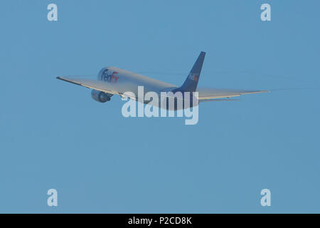 FedEx Express Boeing 767-300 Frachtflugzeug Klettern entfernt vom internationalen Flughafen von Los Angeles, LAX, Kalifornien, USA. Kondensstreifen Form über den Flügel. Stockfoto