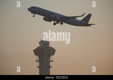 American Airlines Airbus A321 Jet Airliner am internationalen Flughafen von Los Angeles, LAX, bei Sonnenaufgang. Die ATC-Turm unten. Stockfoto