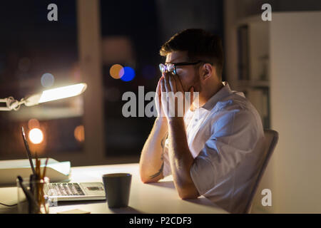 Müde Geschäftsmann mit Laptop in der Nacht Büro Stockfoto