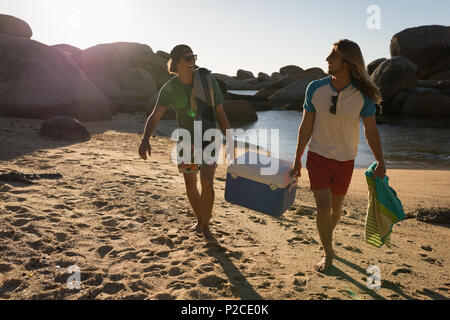 Männliche Freunde Durchführung esky im Strand Stockfoto