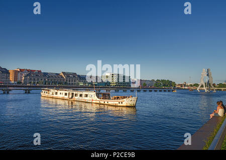 Blick auf den Berliner Spree mit der Skulptur Molekül Männer und ein verlassenes Schiffswrack Stockfoto