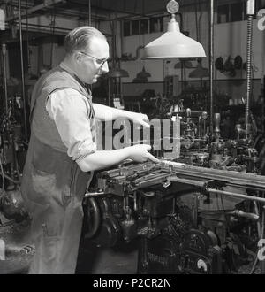 1950er Jahre, historische, ein Mann, der Arbeiter, die die komplizierte mechanische Maschinen in einer Fabrik der Ära England, UK. Stockfoto