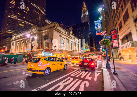 Yellow Cabs und Autos vorbei an der Grand Central Terminal Gebäude in Richtung das Chrysler Gebäude auf einem langen Nacht in Manhattan, New York City Stockfoto