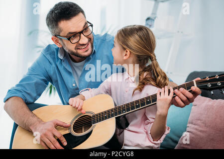 Vater lehre Tochter Gitarre spielen zu Hause Stockfoto