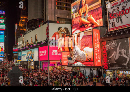 Menschenmassen versammeln sich das Schauspiel der Times Square bei Nacht mit der beleuchteten und animierte Werbung Bildschirme in Manhattan, New York City Stockfoto