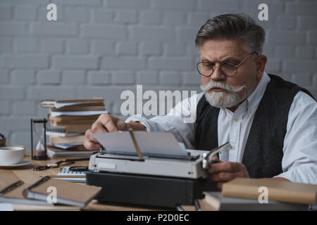 Schweren grauen Haaren Schriftsteller arbeiten mit Schreibmaschine Stockfoto