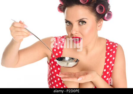 Close-up Portrait von emotionalen Plus size Hausfrau Kochen mit Schöpfkelle isoliert auf weißem Stockfoto