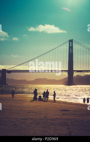 Eine Silhouette Gruppe von Freunden am Strand unter der Golden Gate Bridge in San Francisco Stockfoto