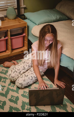 Mädchen sitzt auf dem Boden mit ihrem Laptop Stockfoto
