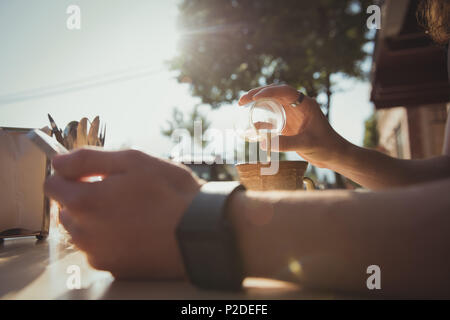 Man gießt Milch im Kaffee Stockfoto