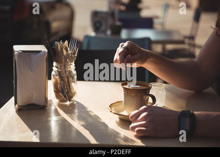 Man rühren Kaffee mit Löffel Stockfoto