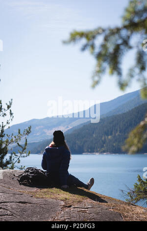 Weibliche Wanderer auf Felsen sitzend Stockfoto