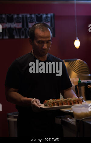 Koch, die Sushi in einem Fach Stockfoto