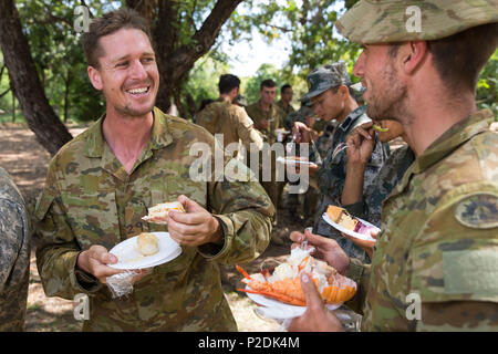 Australische Armee Sgt Dominic Hamon Gespräche mit einem anderen Soldaten während des Festes nach Abschluss der 5-tägigen Phase des Überlebens der Übung Kowari 2016, in der Daly River Region des Northern Territory am 8. September 2016. Kowari ist eine australische Armee-gehostete überleben Fähigkeiten trainieren, die Zusammenarbeit im Bereich der Verteidigung zwischen den Truppen aus den USA, Australien und China zu erhöhen. (Australian Defence Force Foto von Cpl. Jake Sims) Stockfoto