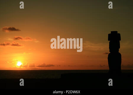 Atemberaubende Aussicht auf den Sonnenuntergang über dem Pazifischen Ozean mit der Moai Silhouette in der Ahu Tahai, Easter Island, Chile Stockfoto