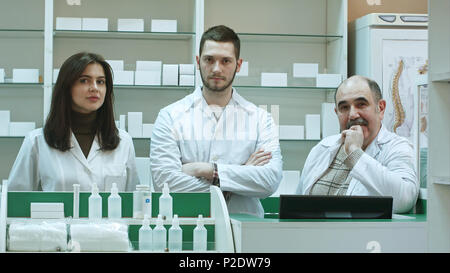 Positive Team von Apothekern bei Camera in der Krankenhausapotheke suchen Stockfoto
