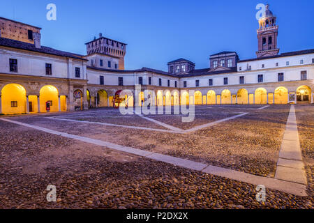 Mittelalterliche Gebäude inneren Hof beleuchtet mit gelben Lichter gegen den blauen Himmel am frühen Morgen. Piazza Castello, Mantua, Italien. Juni 10, 2018 Stockfoto