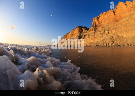 Surfen Sie wäscht auf Torrey Pines State Beach mit den Klippen von Torrey Pines State Reserve im Hintergrund. San Diego, Kalifornien. Stockfoto