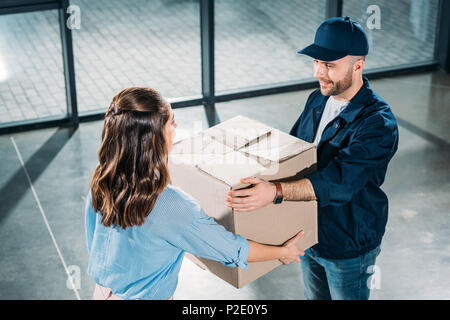 Kurier- und Frau mit Karton Stockfoto