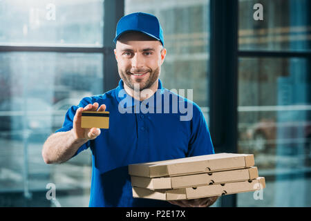 Kurier mit Pizzas in Boxen mit Kreditkarte Stockfoto