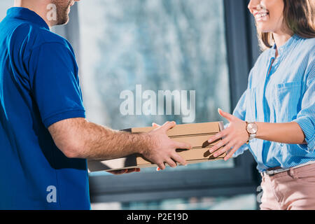 Frauen, die Pizzas in Boxen von Delivery Man Stockfoto