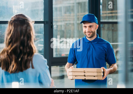 Frauen, die Stapel Pizzen in Kartons von Courier Stockfoto