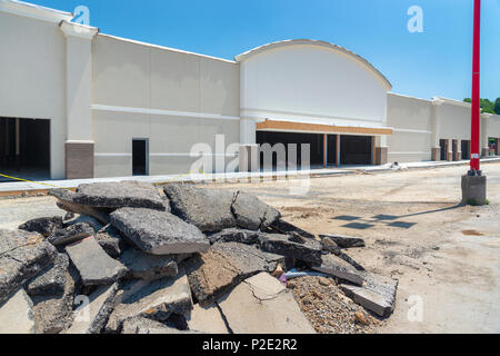 Neuen streifen Einkaufszentrum im Bau. Es gibt einen großen Haufen von zerrissen Pflaster im Vordergrund. Stockfoto