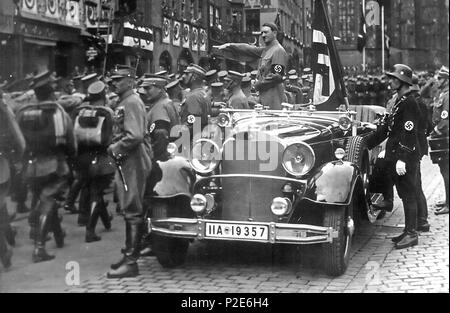 . Englisch: Parade von SA-Truppen hinter Hitler, Nürnberg 1935. Im Auto mit Hitler: Die Blutfahne, hinter dem Auto: SS-Mann en: Jakob Grimminger Träger der Blutfahne Flagge. Von der Reichsparteitag der NSDAP 10.-16. September 1935 (siehe auch Datei:Bundesarchiv Bild 183-1982 -0809-502, Nürnberg, Reichsparteitag, SA-Marsch.jpg English: Nürnberg, eine Parade der SA marschieren ein Hitler vorbei. Im Auto hinter Hitler: Sterben de: Blutfahne (NSDAP), rechts daneben der SS-Mann de: Jakob Grimminger, der Träger der Blutfahne Krieg. September 1935. Charles Russell Collection, Nara. 45 Reichsparteitagnov 193 Stockfoto