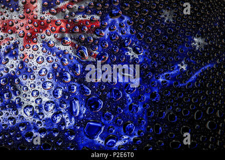 Nahaufnahme von einem Tropfen Wasser vor dem Hintergrund der nationalen Flagge Australien auf einem isolierten Hintergrund Stockfoto