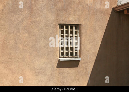 Holz Fenster mit Leisten auf einer Adobe Wand eines Hauses in New Mexico Stockfoto