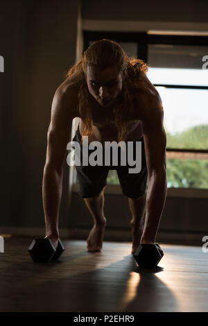 Mann tun Push-ups mit Hanteln Stockfoto
